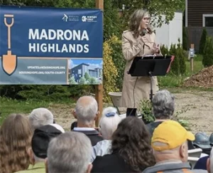 Woman speaking outdoors in front of a crowd at a HMF event